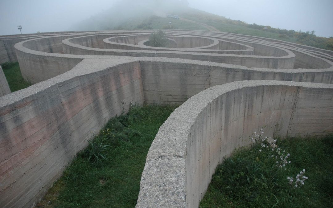 Photo d'un labyrinthe en pierre se perdant dans la brume